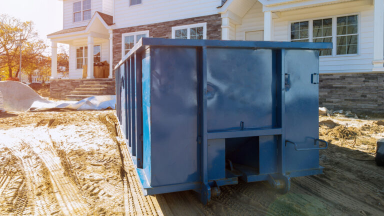 Blue dumpster in front of a house