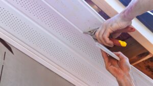 Hands using pliers to fix a home's soffit
