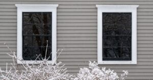Snowy exterior of a home that is zoomed in on two windows